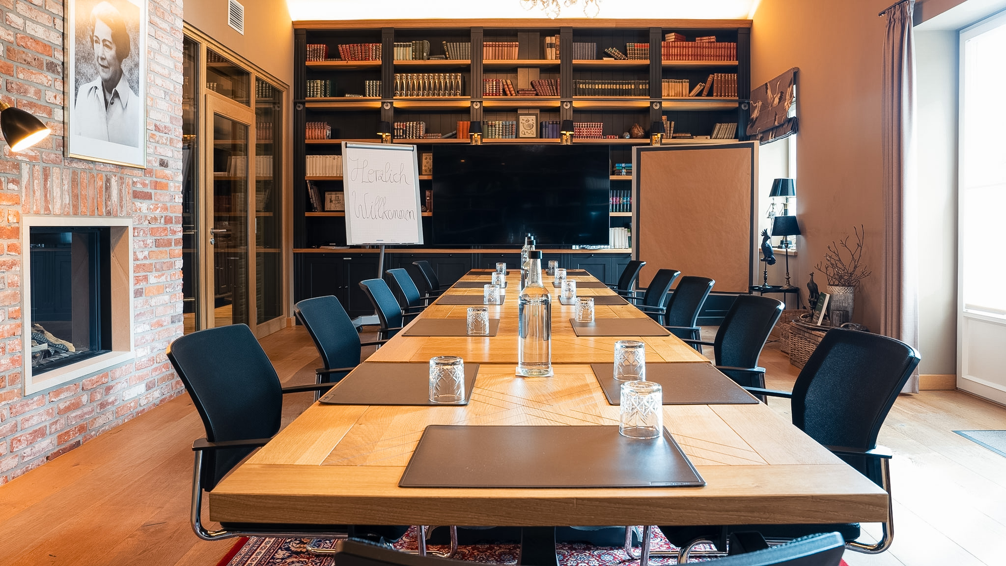 Tagungsraum Bibliothek auf Gut Altona - Konferenztisch vor Bücherwand und Kamin
